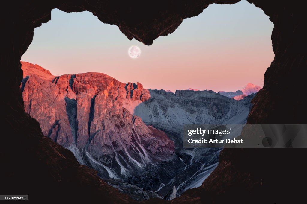 Romantic landscape with heart shape of the Alps mountains with full moon.