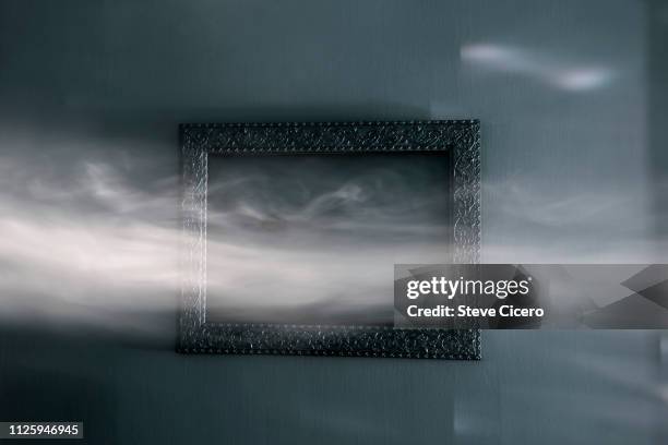 sunlight illuminating smoke lingering past wall frame - lingering stock-fotos und bilder