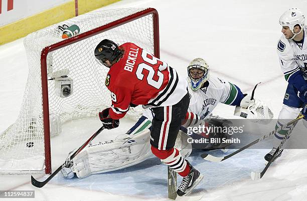 Bryan Bickell of the Chicago Blackhawks scores on Vancouver Canucks' goalie Roberto Luongo as Kevin Bieksa of the Canucks watches from the side in...