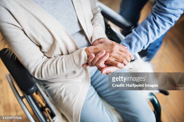 a midsection of senior couple at home, a husband looking after his disabled wife. - assist health stock-fotos und bilder