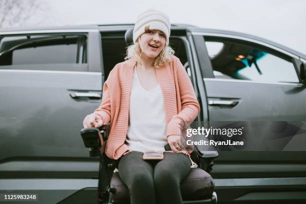 cheerful young woman in wheelchair entering vehicle - motorized wheelchair stock pictures, royalty-free photos & images