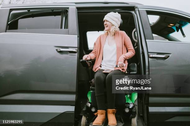 cheerful young woman in wheelchair entering vehicle - disabled accessibility stock pictures, royalty-free photos & images