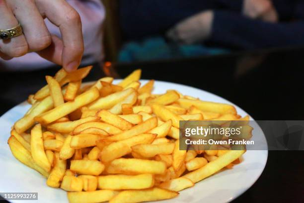 a plate of french fried potatoes in a paris bistro - frites stock pictures, royalty-free photos & images
