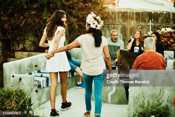 mother and adult daughter walking hand in hand in backyard during family party - garden party stock pictures, royalty-free photos & images