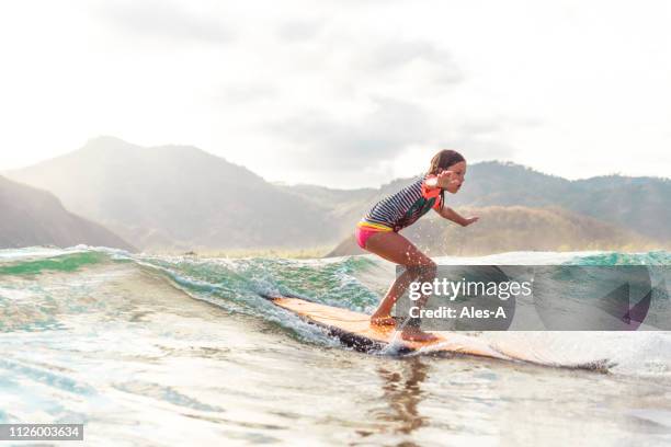 cute little girl surfing - indonesia surfing stock pictures, royalty-free photos & images