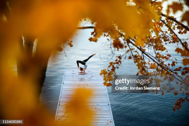 a woman doing yoga on a dock - whitefish foto e immagini stock