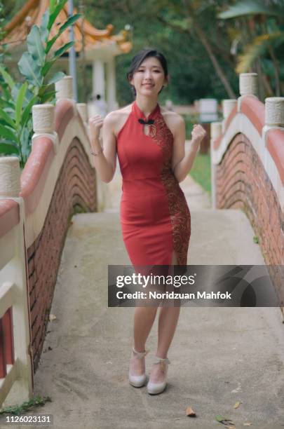 a young and attractive chinese woman wear red cheongsam with different pose - traditional festival ストックフォトと画像