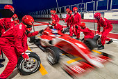 Red formula race car leaving the pit stop