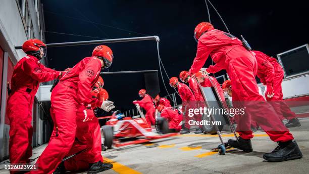 formula race car driving into the pit - pitstop team stock pictures, royalty-free photos & images