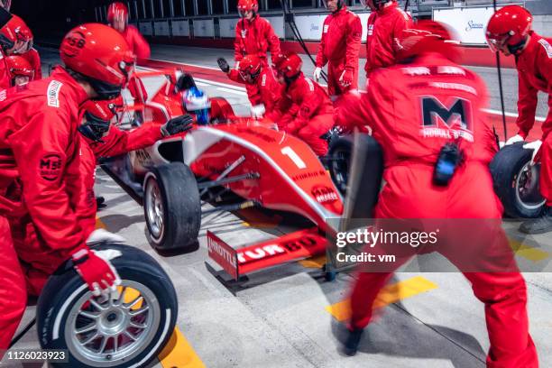 pit crew working on a red formula race car - pitstop team stock pictures, royalty-free photos & images