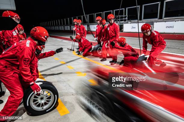 red formula race car leaving the pit stop - pit stop stock pictures, royalty-free photos & images