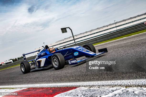 blaue formel-rennwagen auf der strecke - formula 1 car stock-fotos und bilder