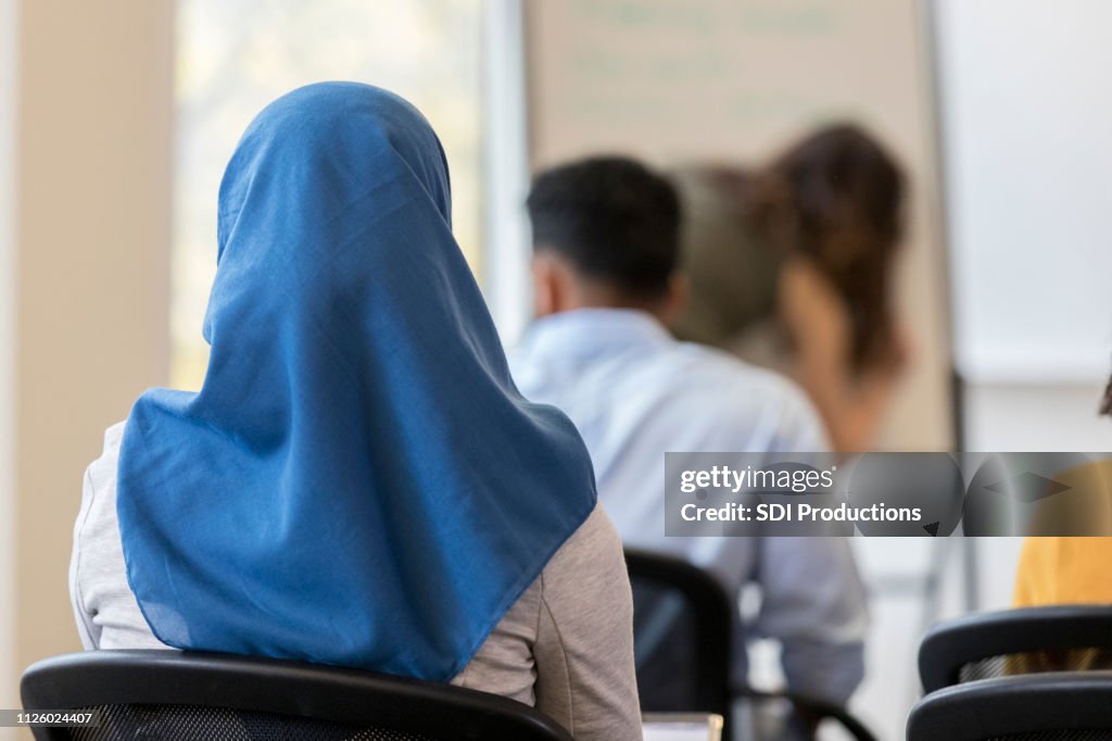Rear view of woman wearing hijab sitting in classroom