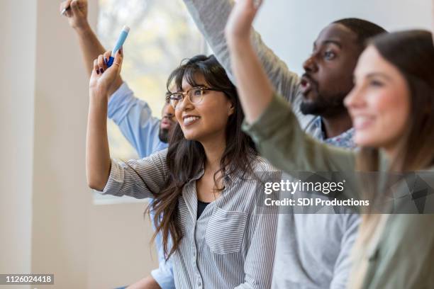 gruppe von geschäftsleuten, die hände erhebend, während schulung - begehren stock-fotos und bilder
