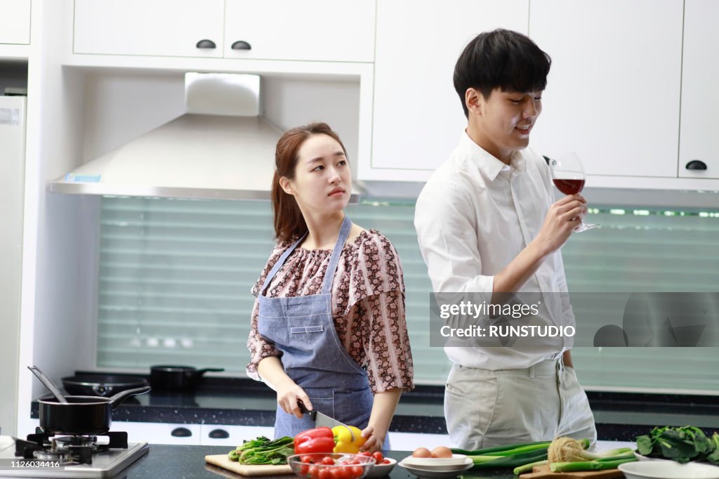 Man drinking wine while woman looking displeased