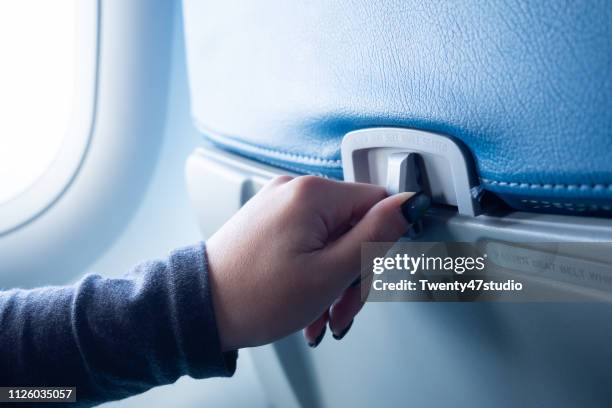 crop image of hand open passenger food tray in airplane - airplane tray stock-fotos und bilder