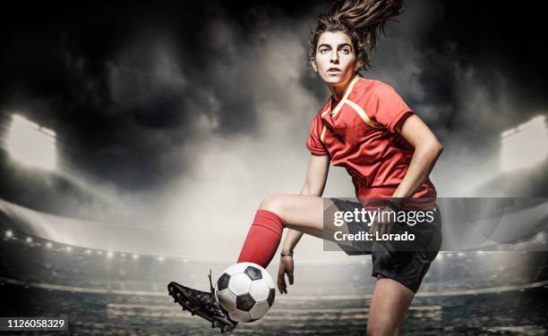 weiblichen fußballspieler in aktion in einem stadion - frauenfußball stock-fotos und bilder