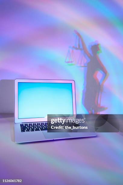 laptop and shadow of lady justice, conceptual image of cyber crime - lady justice statue stock pictures, royalty-free photos & images