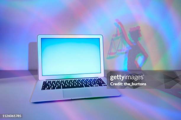 laptop and shadow of lady justice, conceptual image of cyber crime - lady justice technology stock pictures, royalty-free photos & images
