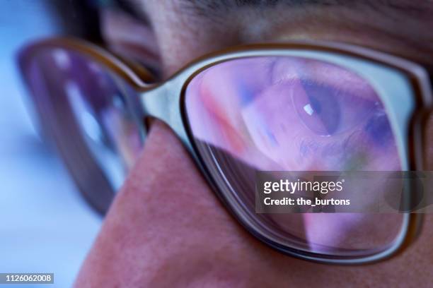 close-up of woman with eyeglasses looking to computer monitor - eye test equipment stockfoto's en -beelden