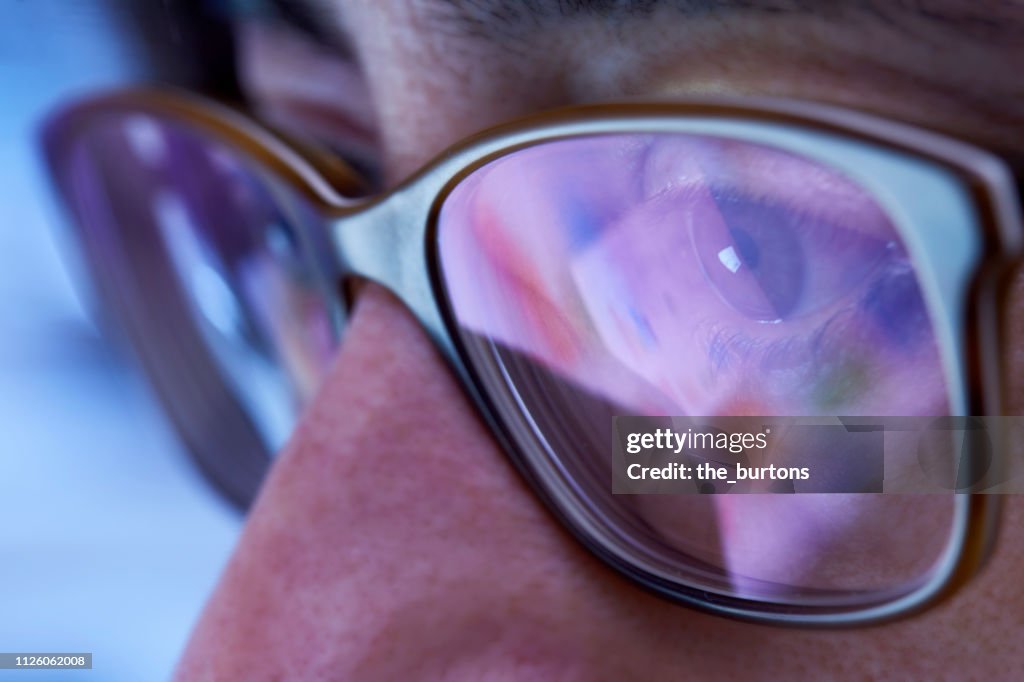 Close-up of woman with eyeglasses looking to computer monitor