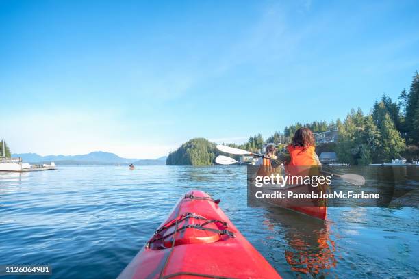 perspectiva personal de ocean kayak después de familia multiétnica en canoa - isla de vancouver fotografías e imágenes de stock