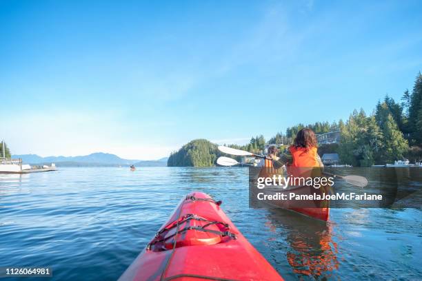 perspectiva personal de ocean kayak después de familia multiétnica en canoa - vancouver island fotografías e imágenes de stock