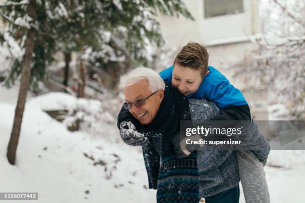 winter fun in the snow - grandfather child snow winter stock pictures, royalty-free photos & images