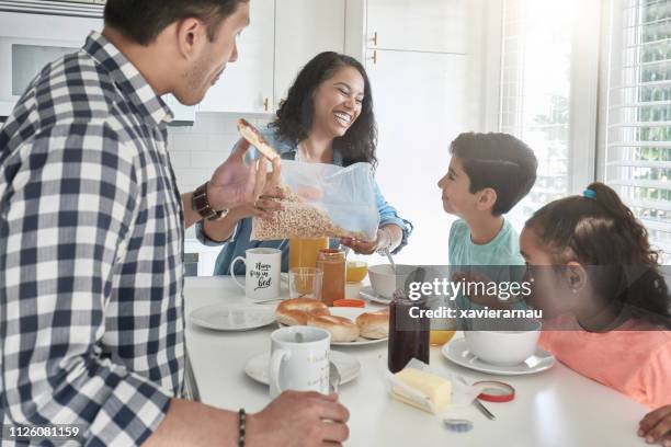 familia feliz desayunando en la cocina en casa - breakfast cereal fotografías e imágenes de stock