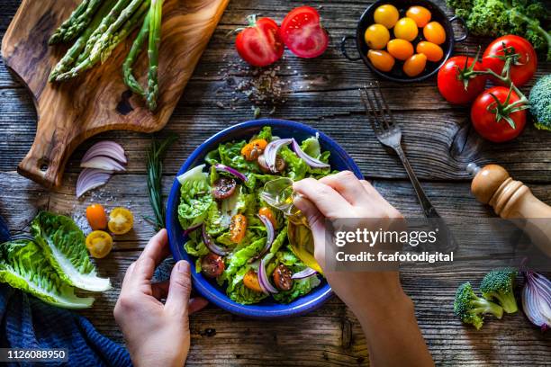 dressing fresh organic vegetables salad with olive oil - molho vinagrete imagens e fotografias de stock