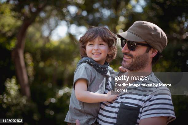 dad and toddler laughing together at the park - fashionable dad stock pictures, royalty-free photos & images