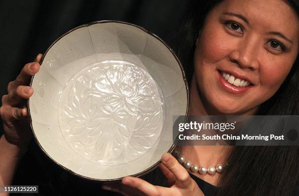 Edie Hu, Senior Specialist, Chinese Ceramics and Works of Art Departments shows a large flower-shaped bowl is " The Clark Ding Basin ", A Magnificently Carved Dingyao Basin, Northern Song Dynasty, expected to fetch in excess of HK$60 million, at Sotheby's Edie Hu, Senior Specialist, Chinese Ceramics and Works of Art Departments shows a large flower-shaped bowl is " The Clark Ding Basin ", A Magnificently Carved Dingyao Basin, Northern Song Dynasty, expected to fetch in excess of HK$60 million, at Sotheby's