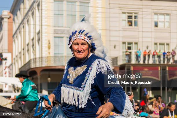 un homme vêtu d’un costume d’indien sur un cheval dans la rue lors de la célébration de mardi gras à new orleans carnaval, louisiane, etats-unis - costume dindien photos et images de collection