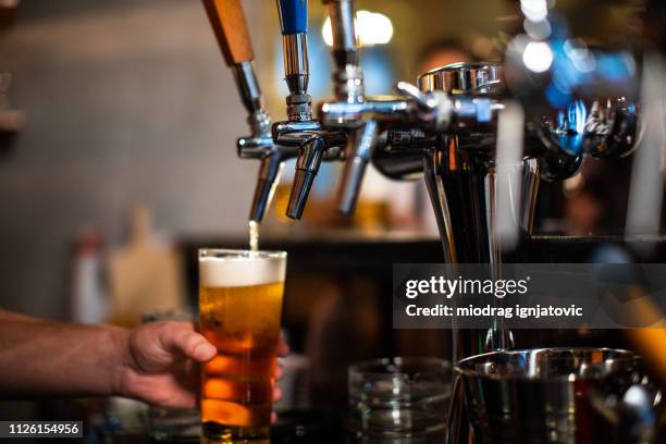 verter la cerveza - tirador fotografías e imágenes de stock