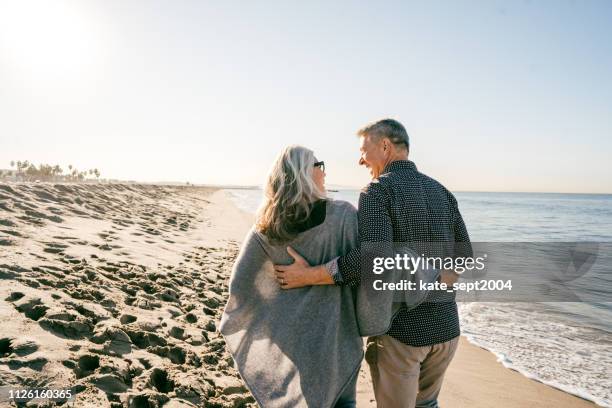 how to organize your finances for retirement - older couple hugging on beach stock pictures, royalty-free photos & images