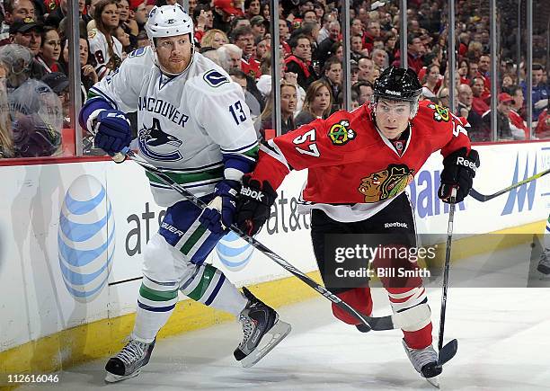 Raffi Torres of the Vancouver Canucks and Ben Smith of the Chicago Blackhawks chase after the puck in Game Four of the Western Conference...