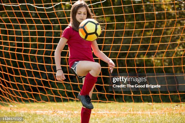 girl bouncing soccer ball on knee - 11-13 2017 stock pictures, royalty-free photos & images