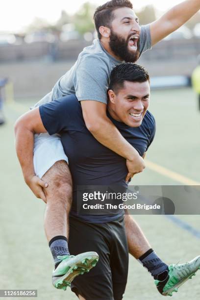 soccer players celebrating victory on field - huckepack nehmen stock-fotos und bilder