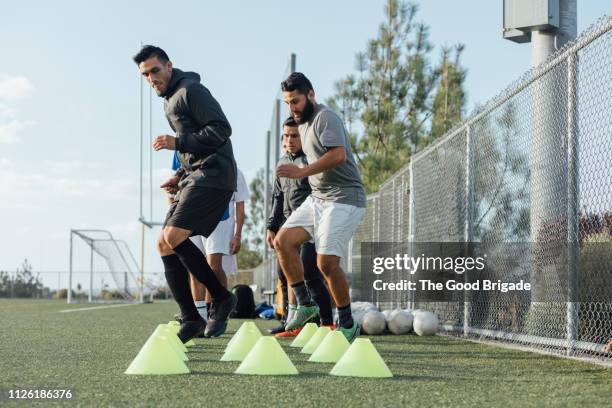 soccer players performing warm up drills - sportoefening stockfoto's en -beelden