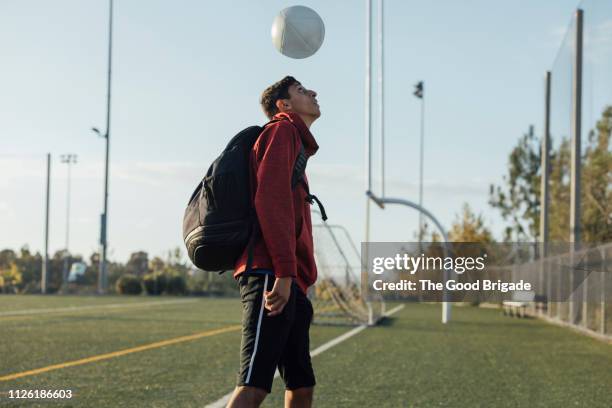 soccer playing bouncing ball on head - heading the ball stockfoto's en -beelden