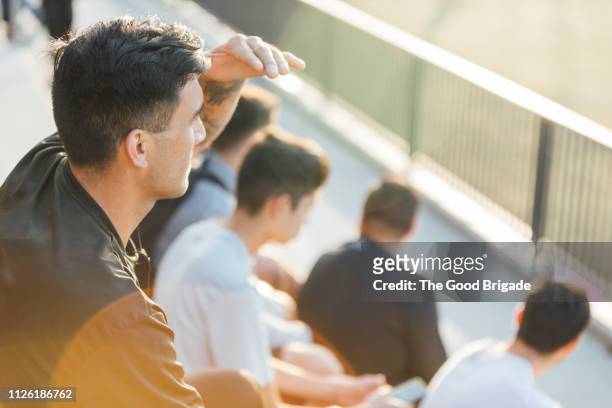 man watching game from stadium bleachers - small group of people stock-fotos und bilder