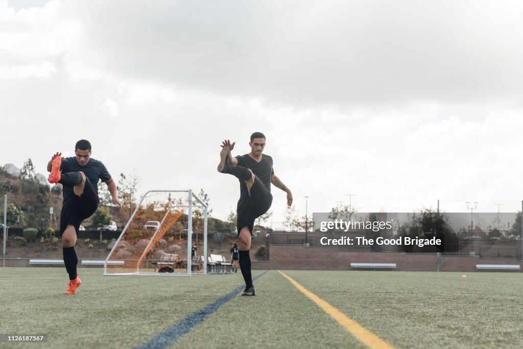 Soccer players performing warm up drills on field