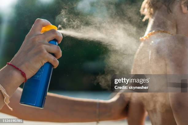 close up van moeder haar zoon met zonnecrème op het strand te beschermen. - sunburned stockfoto's en -beelden