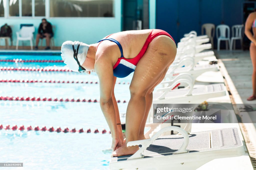 Athlete in position to dive into pool