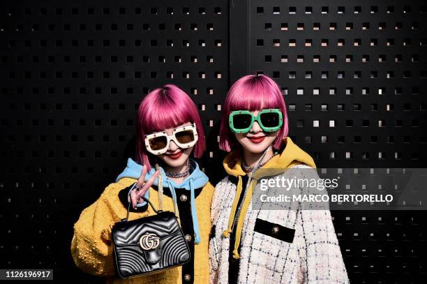 Twin sisters Ami Suzuki and Aya Suzuki, of Japanese music duo Amiaya, display their street style look outside the Gucci women's Fall/Winter 2019/2020...