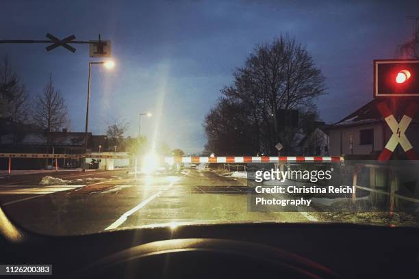 cars waiting at a railway crossing in the morning - auto ampel stock-fotos und bilder