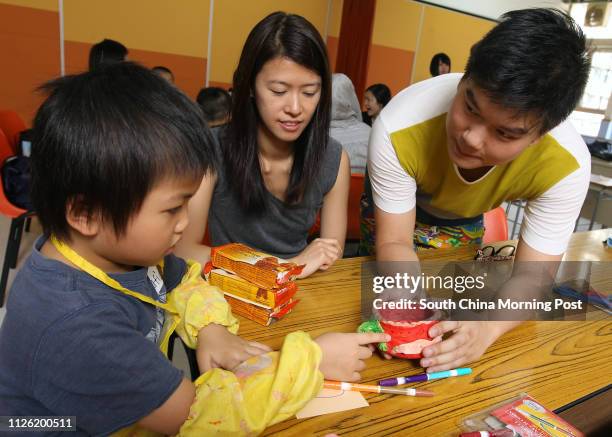 Rafic Lam, 6 yrs., old; May Ling, volunteer and Leonard So, tutor work on the art workshop at Children and Family Services Centre , Hong Kong Society...