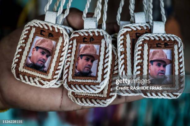 Pendants bearing the image of Mexican drug lord Joaquin "El Chapo" Guzman, are displayed for sale at the narco-saint Jesus Malverde chapel in...