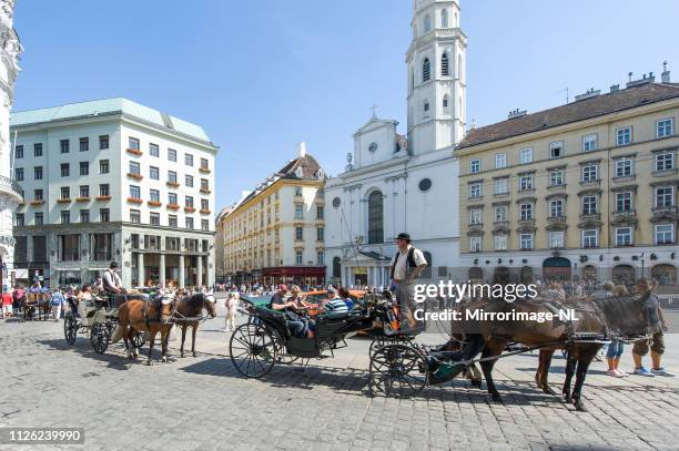 landau carriages and tourists on vienna's st. michael's square - landau stock pictures, royalty-free photos & images