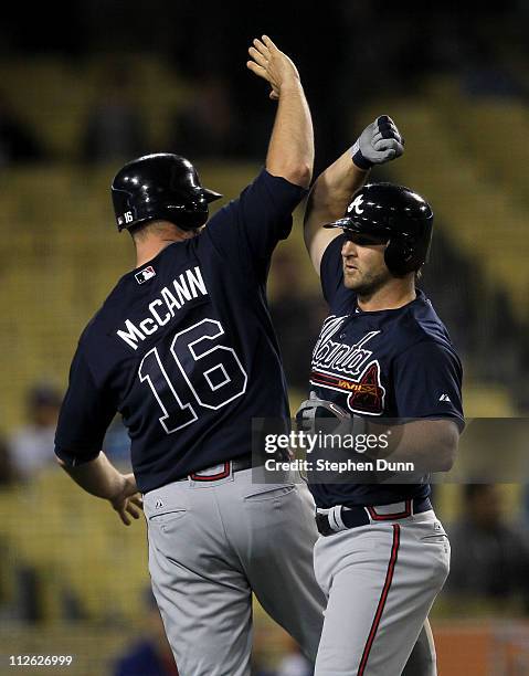 Dan Uggla and Brian McCann of the Atlanta Braves celebrate after Uggla's three run home run iin the ninth inning against the Los Angeles Dodgers on...